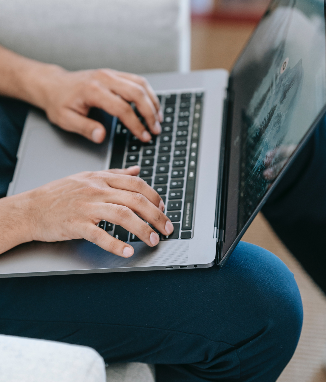 Mann schreibt auf einer Notebook Tastatur